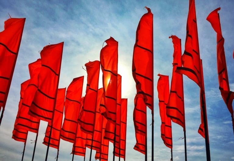 A large number of red flags against the sky as a background - a red flag parade, if you like
